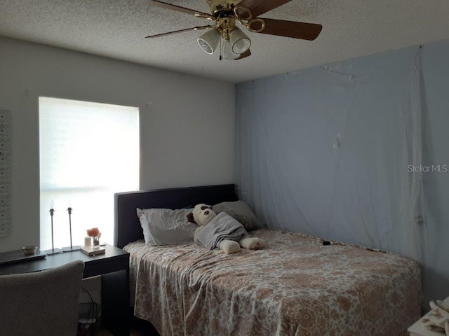 bedroom featuring ceiling fan and a textured ceiling