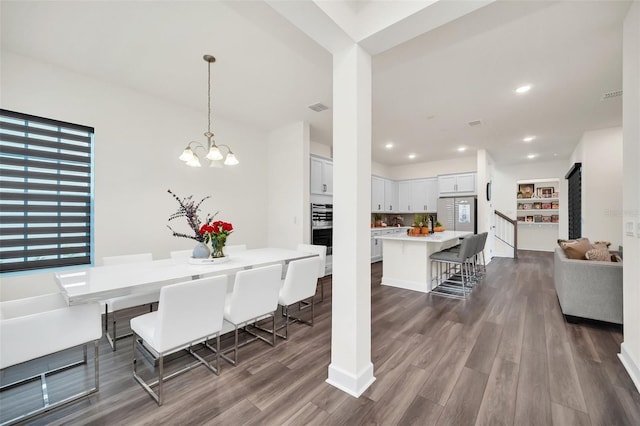 dining space featuring an inviting chandelier and dark hardwood / wood-style flooring