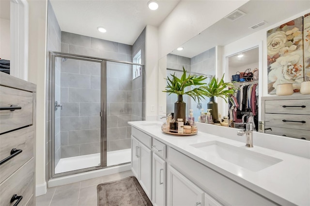 bathroom with walk in shower, vanity, and tile patterned flooring