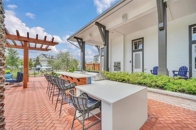 view of patio / terrace featuring an outdoor kitchen and a bar