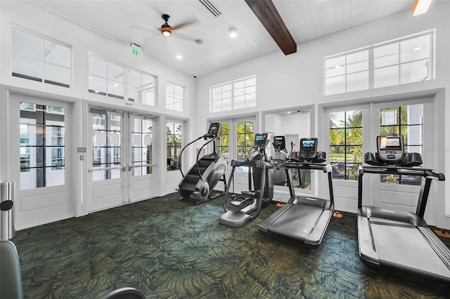 gym with ceiling fan, a towering ceiling, french doors, and dark colored carpet