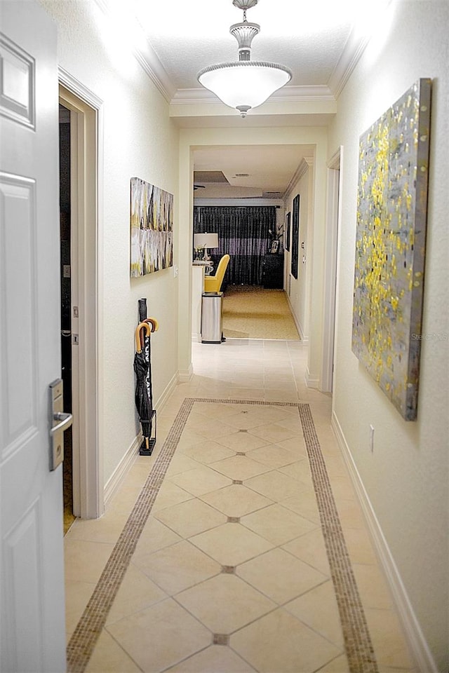 hall featuring light tile floors and crown molding