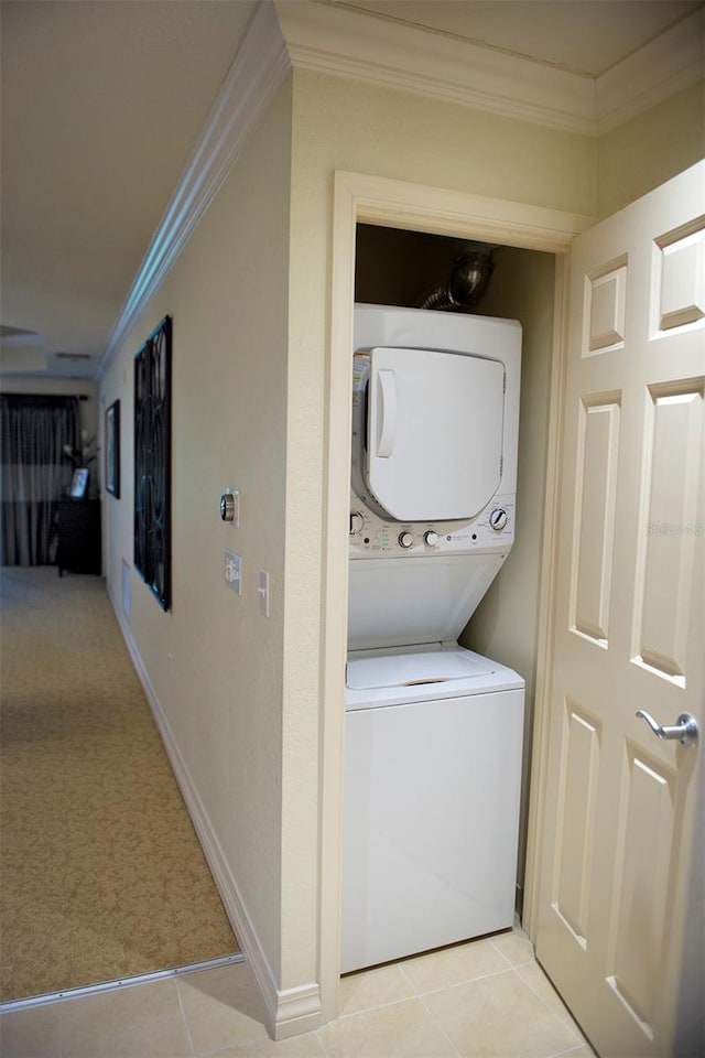 washroom with stacked washer and clothes dryer, crown molding, and light colored carpet