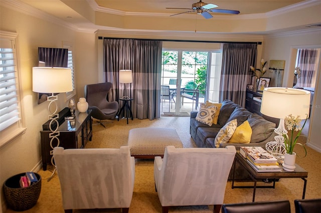 carpeted living room featuring crown molding, ceiling fan, and a tray ceiling