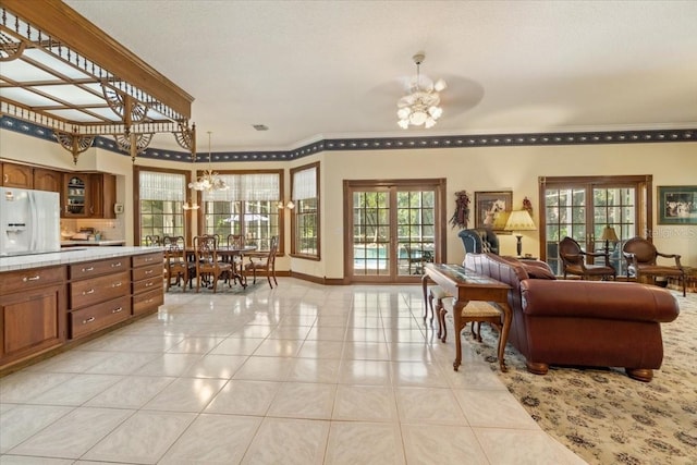 interior space featuring light tile flooring, french doors, and ceiling fan with notable chandelier