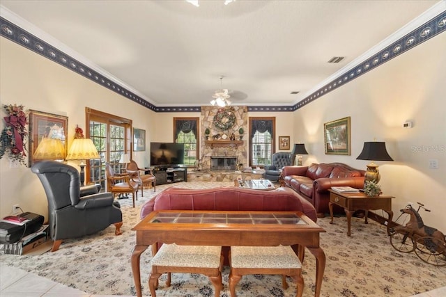 living room featuring light tile floors, crown molding, ceiling fan, and a fireplace