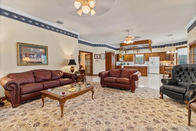 tiled living room featuring ceiling fan with notable chandelier and ornamental molding