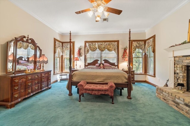 bedroom featuring dark colored carpet, crown molding, ceiling fan, and a fireplace