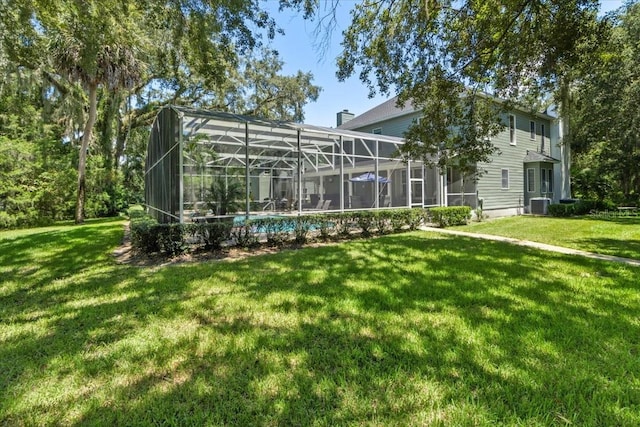 rear view of property featuring a lawn and a lanai