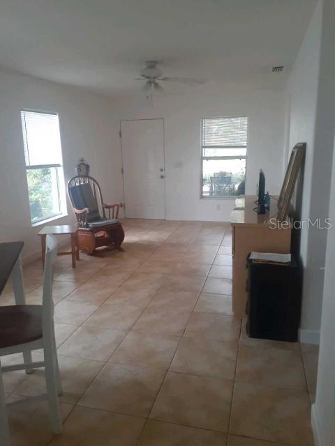 foyer entrance featuring light tile patterned floors and ceiling fan