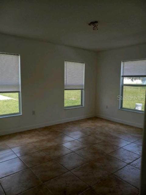 tiled empty room featuring a wealth of natural light