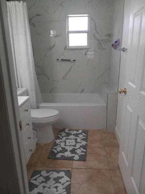 full bathroom with tile patterned flooring, vanity, toilet, and shower / bath combo with shower curtain