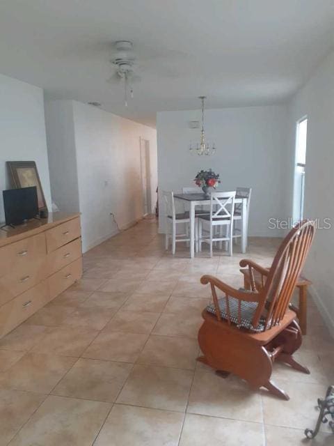 living area featuring light tile patterned floors and ceiling fan