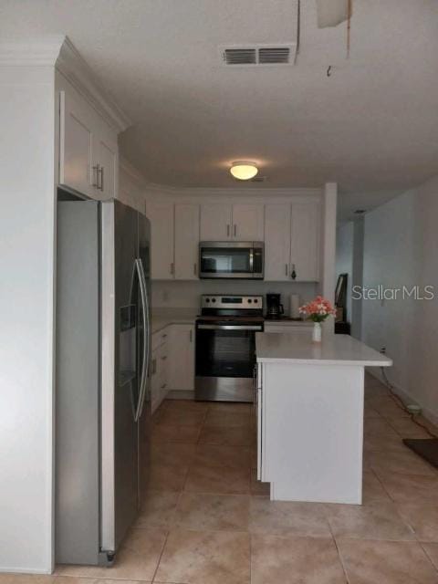 kitchen featuring white cabinetry, light tile patterned flooring, a center island, and appliances with stainless steel finishes