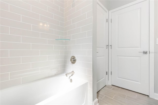 bathroom featuring tile floors and tiled shower / bath