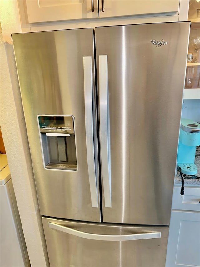 interior details featuring stainless steel refrigerator with ice dispenser