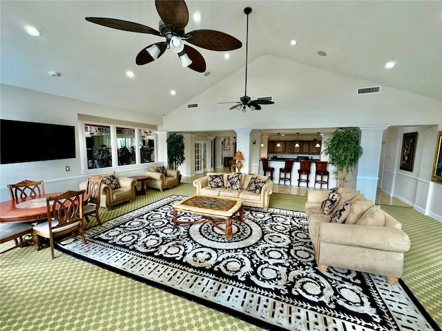 living room with decorative columns, ceiling fan, and high vaulted ceiling