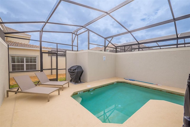 view of swimming pool featuring glass enclosure, grilling area, and a patio