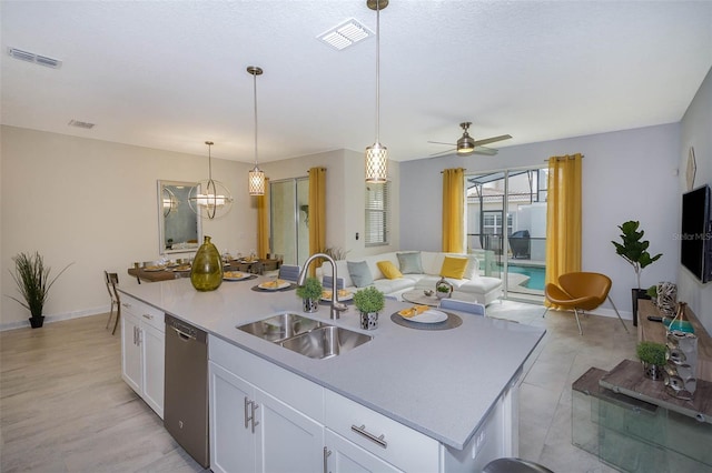 kitchen with white cabinetry, ceiling fan with notable chandelier, a kitchen island with sink, sink, and dishwasher