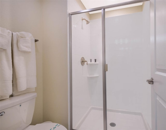 bathroom with toilet and a shower with door