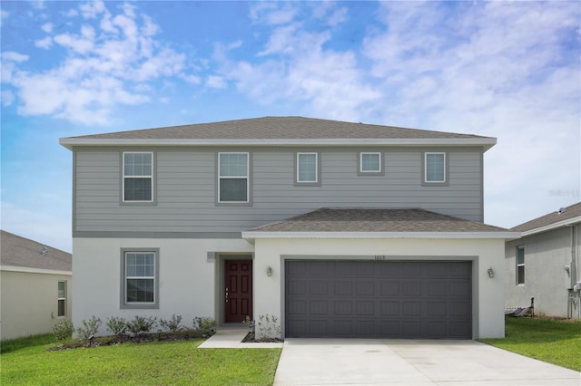 view of property with a front lawn and a garage