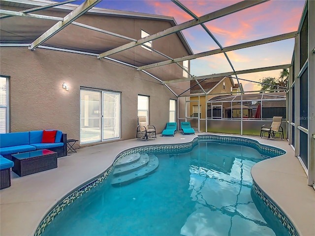 pool at dusk with a patio, an outdoor living space, and a lanai