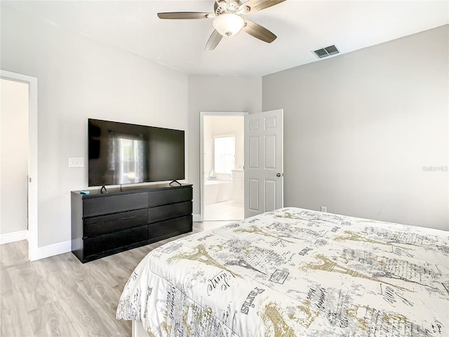 bedroom featuring ensuite bathroom, ceiling fan, and light wood-type flooring