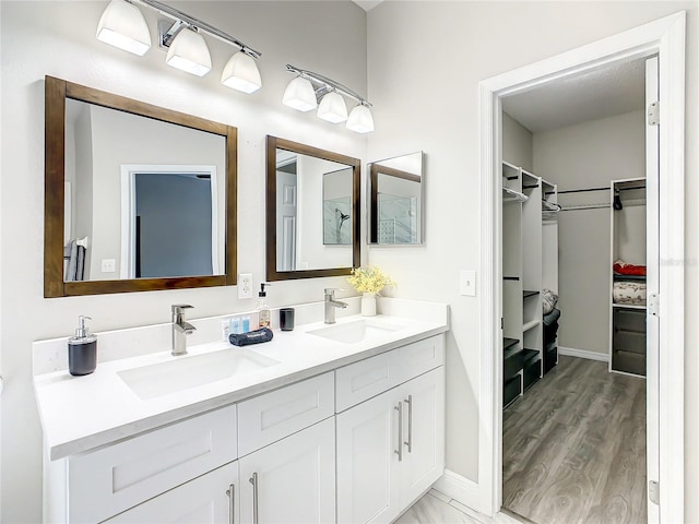 bathroom featuring hardwood / wood-style floors, double sink, and vanity with extensive cabinet space