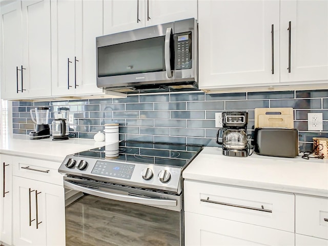 kitchen with white cabinets, tasteful backsplash, and stainless steel appliances