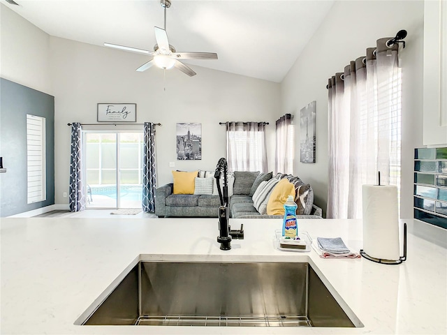 interior space featuring lofted ceiling, ceiling fan, and sink