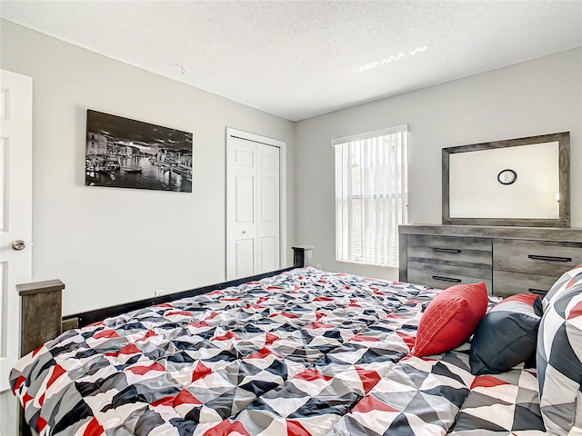 bedroom with a textured ceiling and a closet