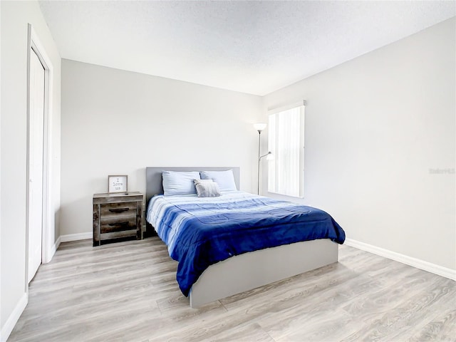 bedroom featuring a textured ceiling and light wood-type flooring