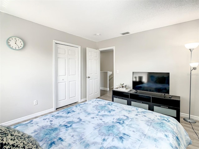 bedroom featuring a textured ceiling and light wood-type flooring