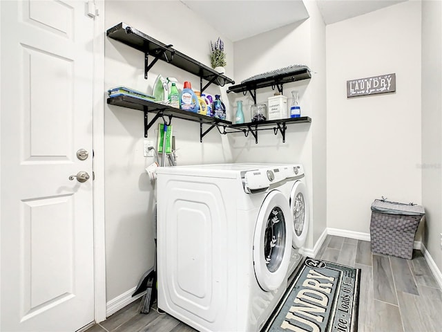 laundry room with independent washer and dryer and light hardwood / wood-style flooring