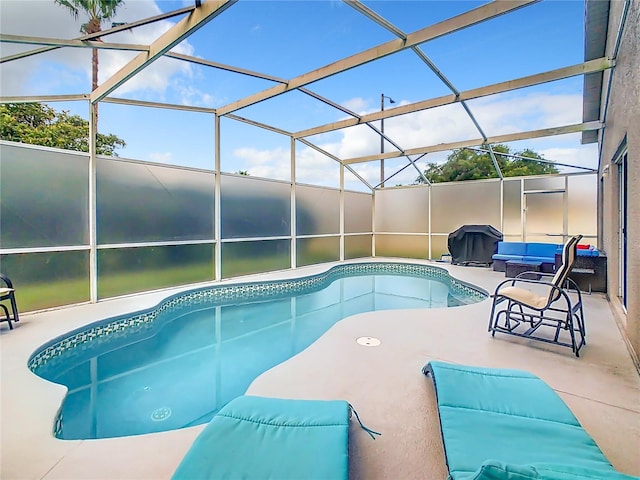 view of swimming pool with a patio and a lanai