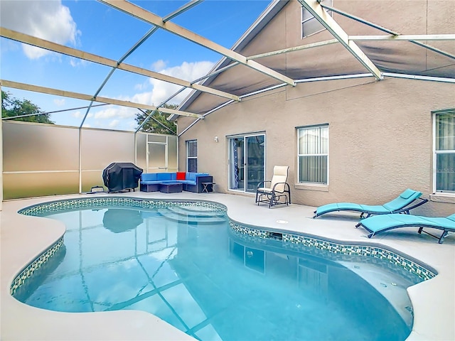 view of pool with outdoor lounge area, a patio area, and a lanai