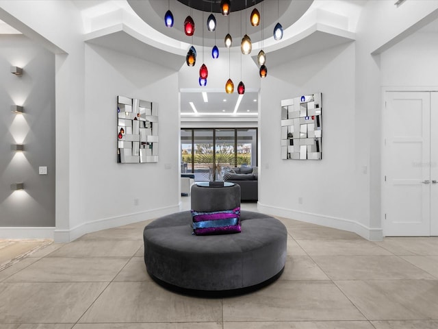 living area featuring light tile floors and a high ceiling