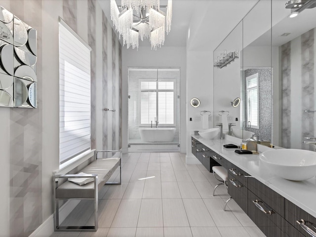 bathroom with a chandelier, a washtub, dual vanity, and tile floors