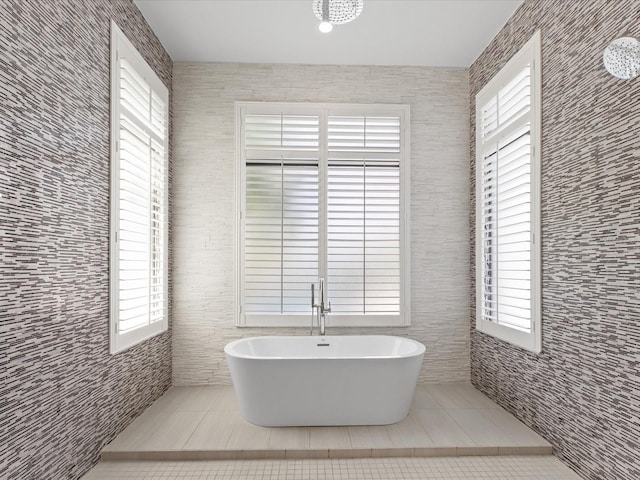 bathroom with tile walls, tile floors, and a bath