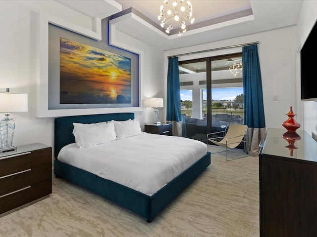 carpeted bedroom with an inviting chandelier and a tray ceiling