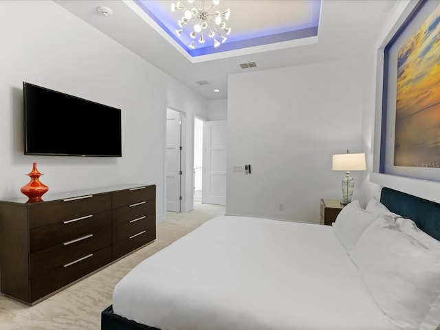 carpeted bedroom with a tray ceiling and a chandelier