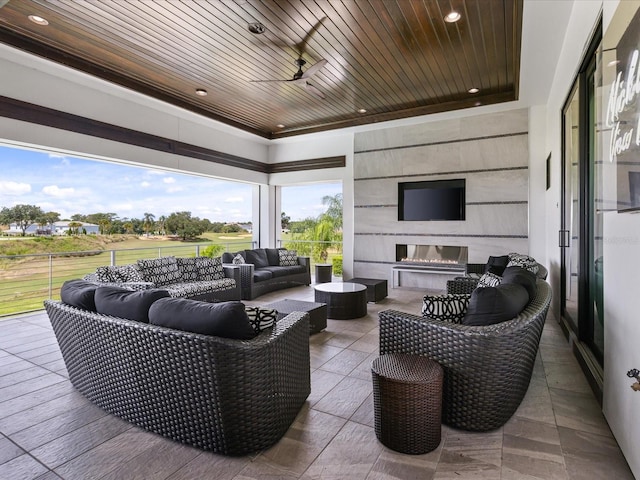 view of terrace with an outdoor living space with a fireplace and ceiling fan