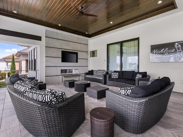 view of patio with ceiling fan and an outdoor living space with a fireplace