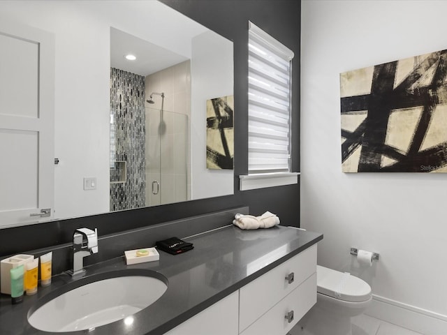 bathroom featuring tile floors, toilet, vanity, and a shower with door