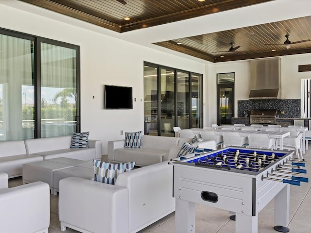 playroom with light tile floors, a tray ceiling, ceiling fan, and wooden ceiling