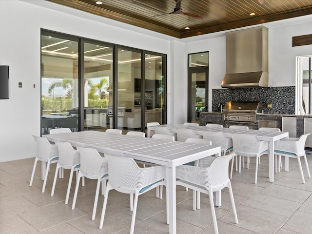 tiled dining space with a raised ceiling, wooden ceiling, and ceiling fan