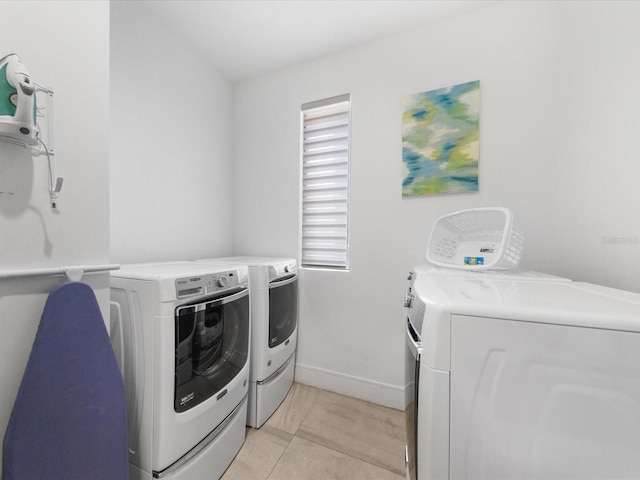 laundry area featuring separate washer and dryer and light tile flooring