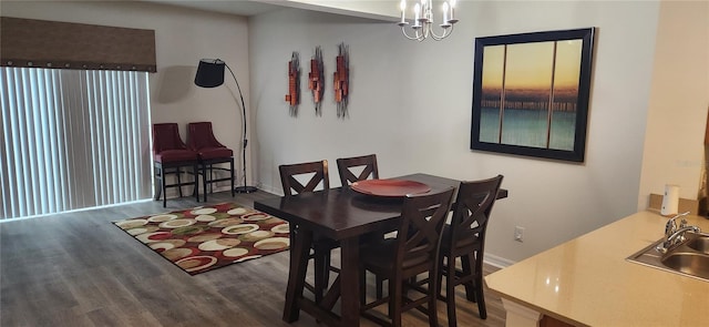 dining space featuring sink, a notable chandelier, and dark hardwood / wood-style flooring