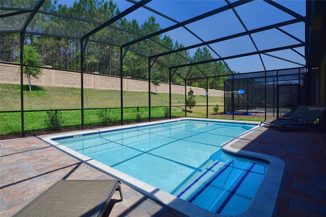 view of pool with a lanai, a lawn, and a patio area