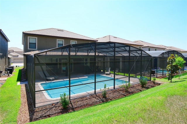 view of pool featuring a lawn and glass enclosure